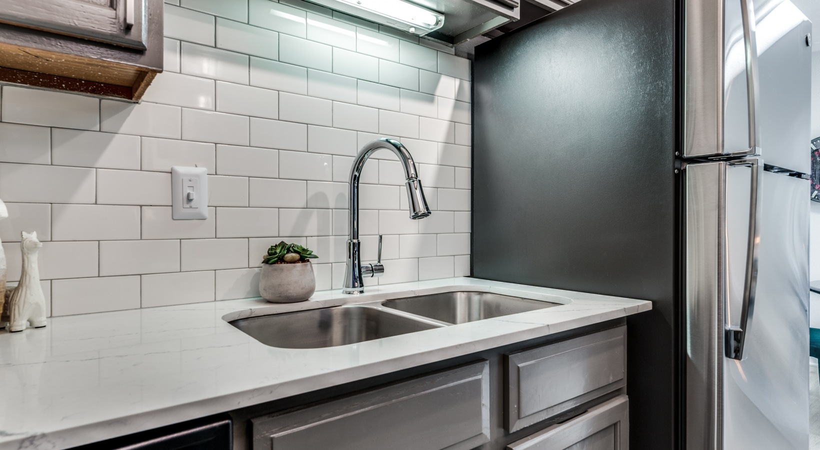 a kitchen with a sink and stainless steel appliances at The  Kace