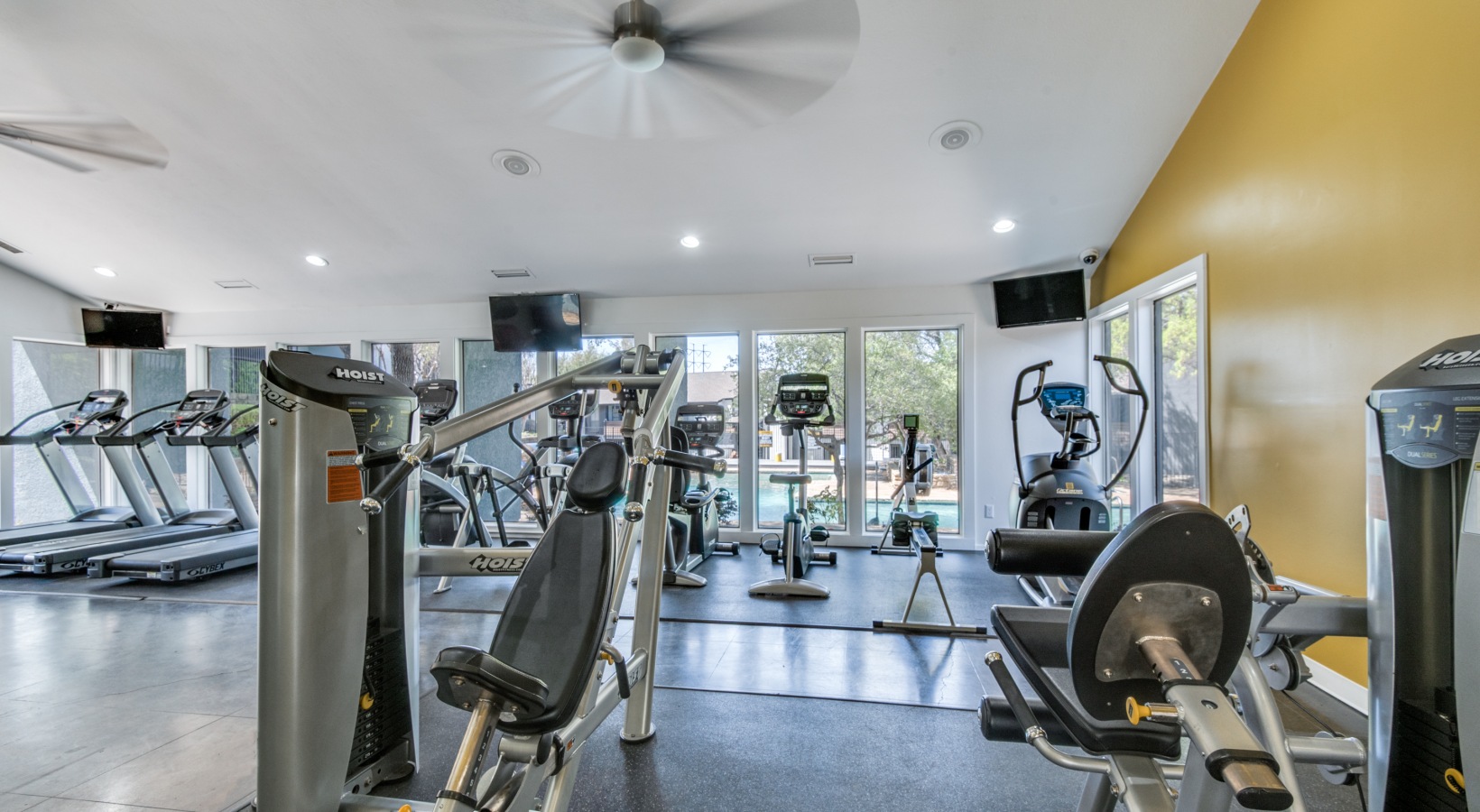 a gym room with exercise equipment and a television at The  Kace