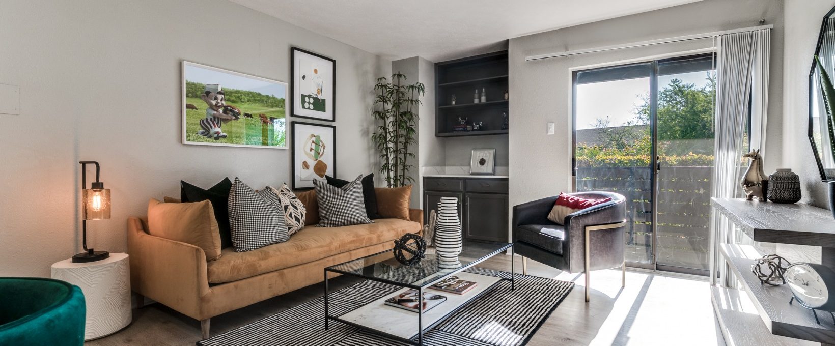 a living room with a couch, coffee table and television at The  Kace