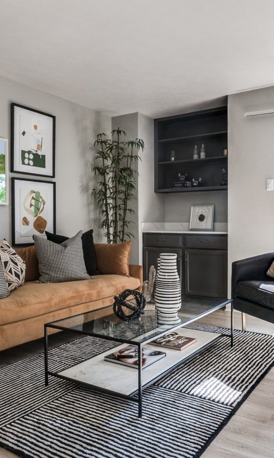 a living room with a couch, coffee table and television at The  Kace