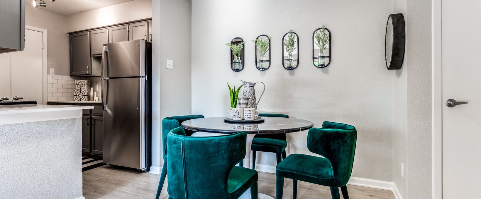 a dining room and kitchen area with green chairs at The  Kace