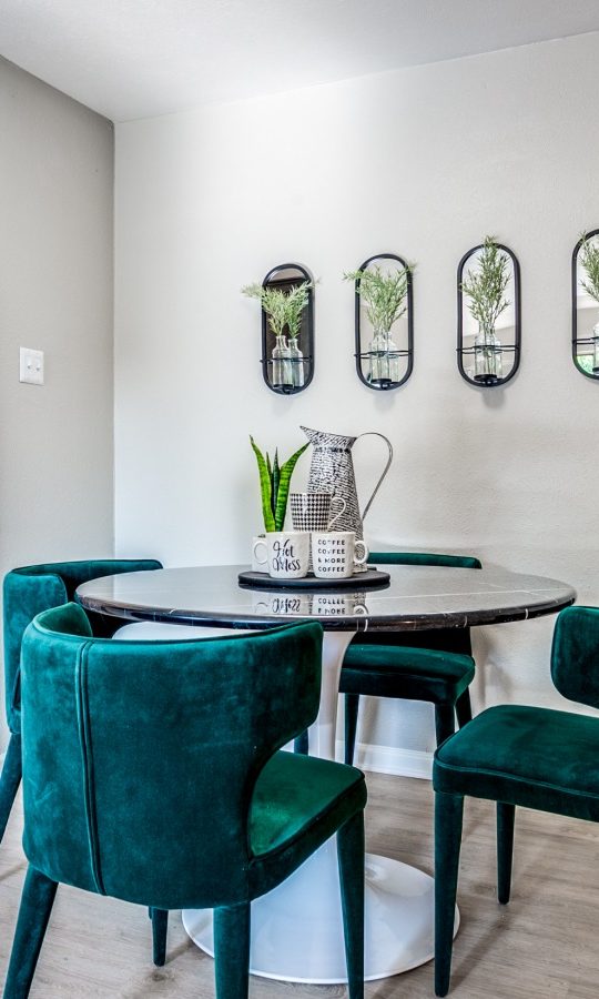 a dining room and kitchen area with green chairs at The  Kace