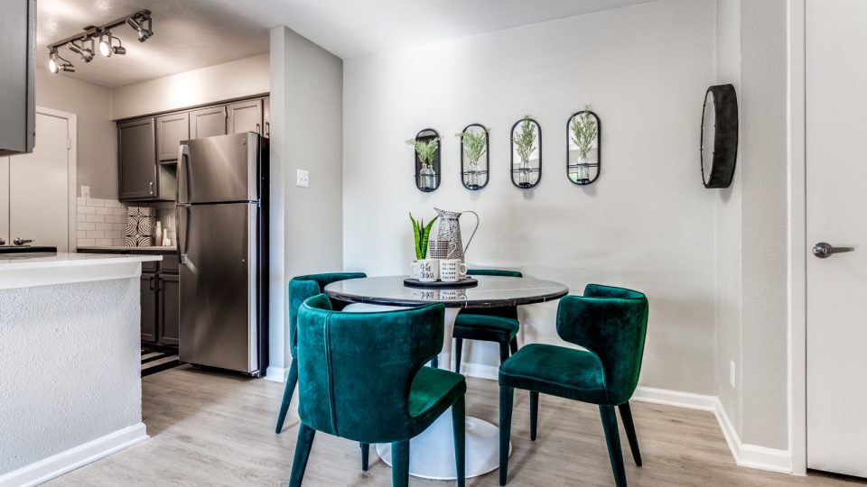 a dining room and kitchen area with green chairs at The  Kace