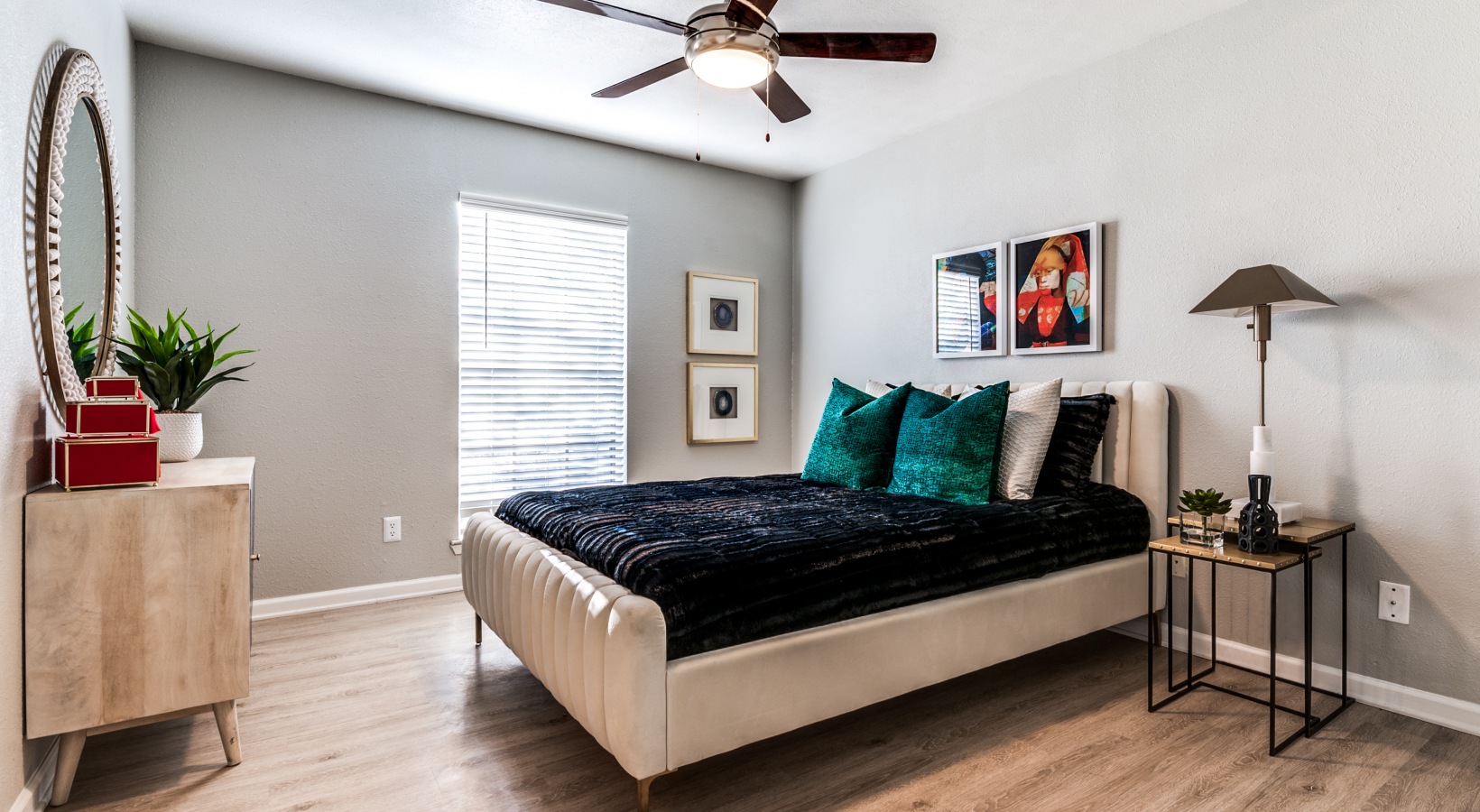 a bedroom with a bed, dresser and ceiling fan at The Kace